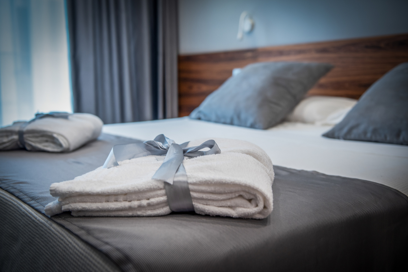 Bathrobe on bed in  a bright luxury hotel room